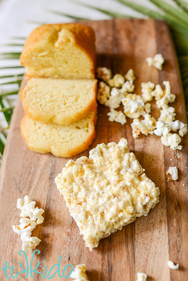 Pound cake and popcorn on a wooden cutting board, surrounding Pound Cake Popcorn Bars.