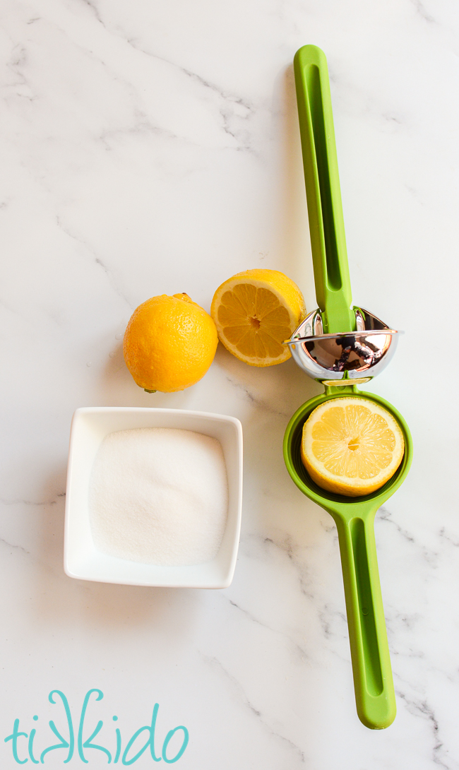 Ingredients for lemon glaze to top lemon loaf cake on a white marble surface.