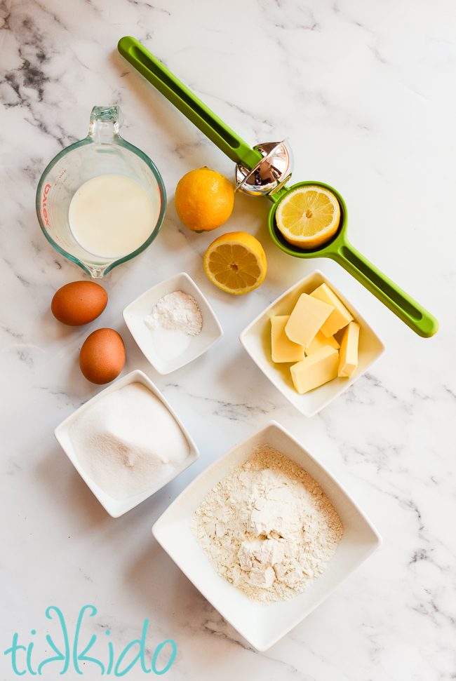 Lemon loaf cake ingredients on a white marble surface.