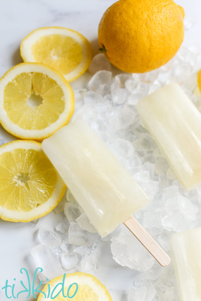 Lemon popsicles on a bed of crushed ice and lemon slices.
