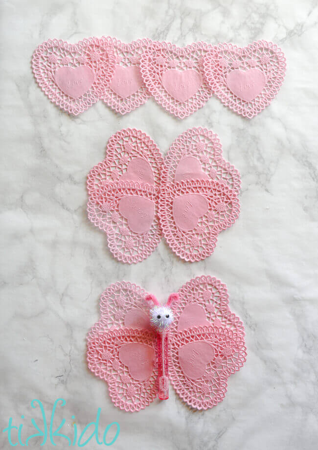Line of four doily hearts, four doily hearts arranged in butterfly wings, and bubbles butterfly body on top of doily wings.