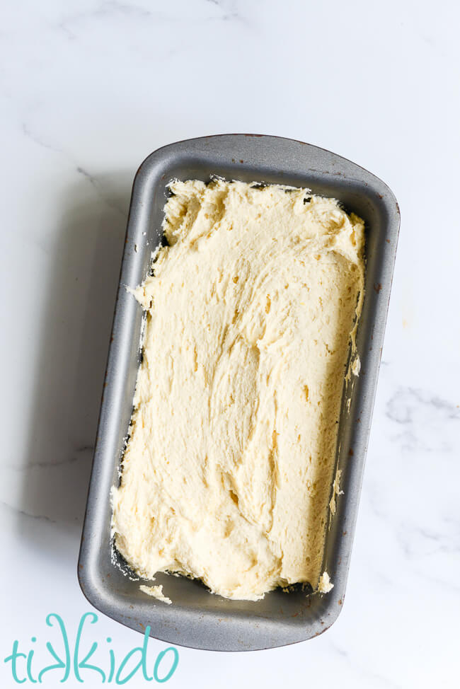 Madeira Cake batter in a bread pan, on a white marble surface.