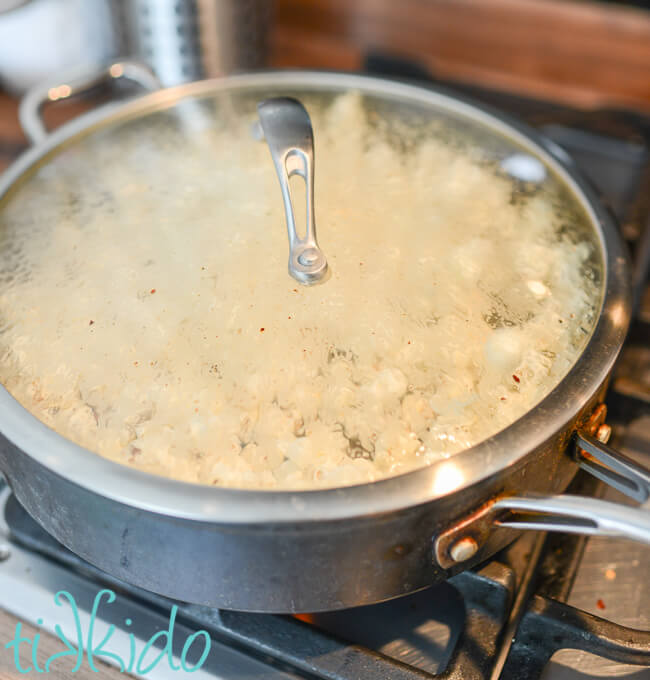 Popcorn being popped in bacon grease on the stovetop to make Maple Bacon Popcorn.