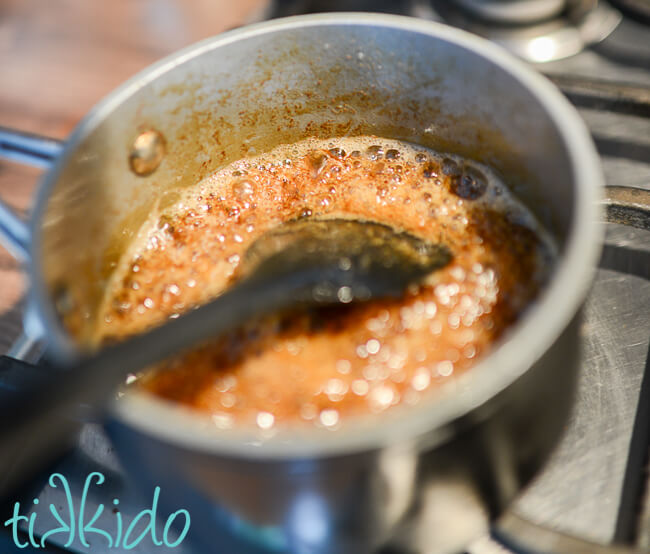 Browned butter and maple syrup being cooked in a small saucepan to make Maple Bacon Popcorn.