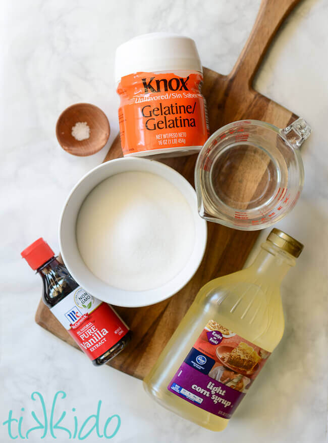 Ingredients for homemade marshmallow sauce on a wooden cutting board.