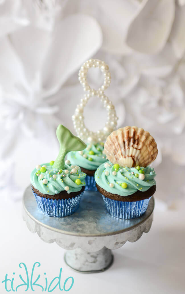 Chocolate Seashells cupcake and mermaid cupcake on a silver cake stand.