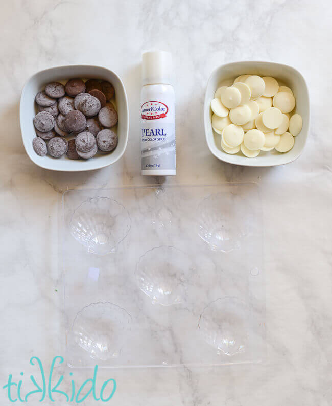 Materials for making chocolate seashells on a white marble background.