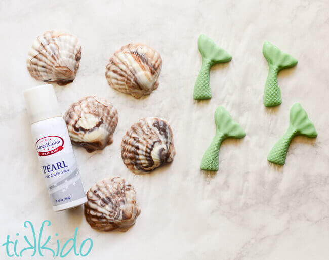 chocolate seashells and chocolate mermaid tails on a white marble background.