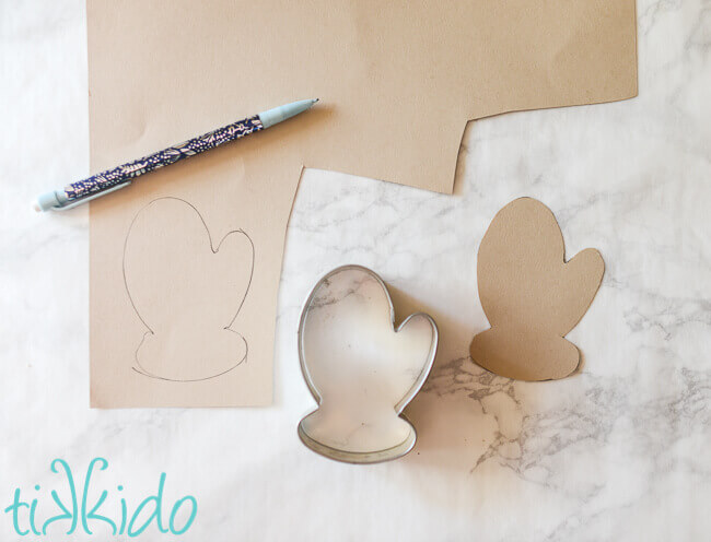 card stock cut into a mitten shape by tracing around a mitten cookie cutter.