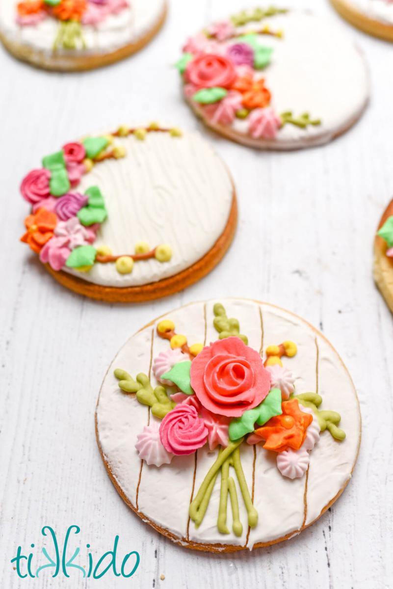 Close up of round sugar cookies decorated with a bouquet of spring flowers made out of royal icing.