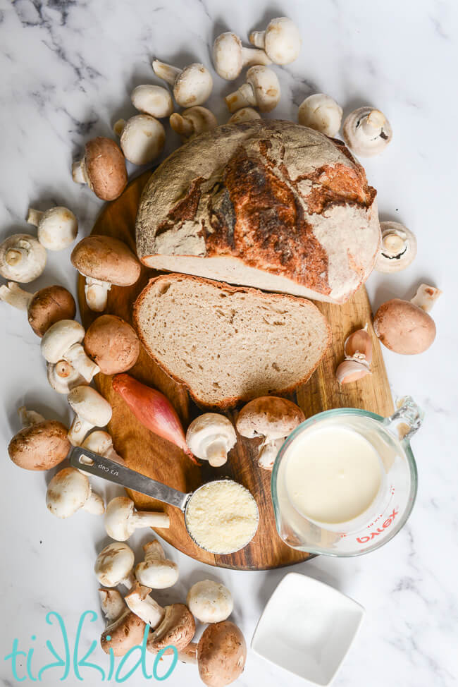 Ingredients for mushrooms on toast recipe on a white marble surface.