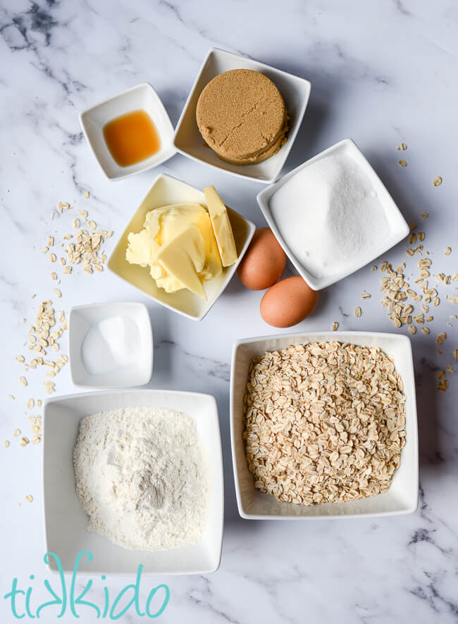 Ingredients for oatmeal cookie recipe on a marble table.