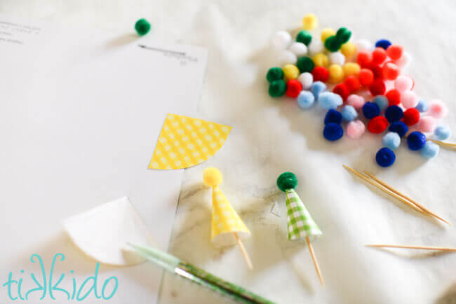 scrapbook paper cut into small triangular shapes and glued into small paper cones, topped with craft pom poms.