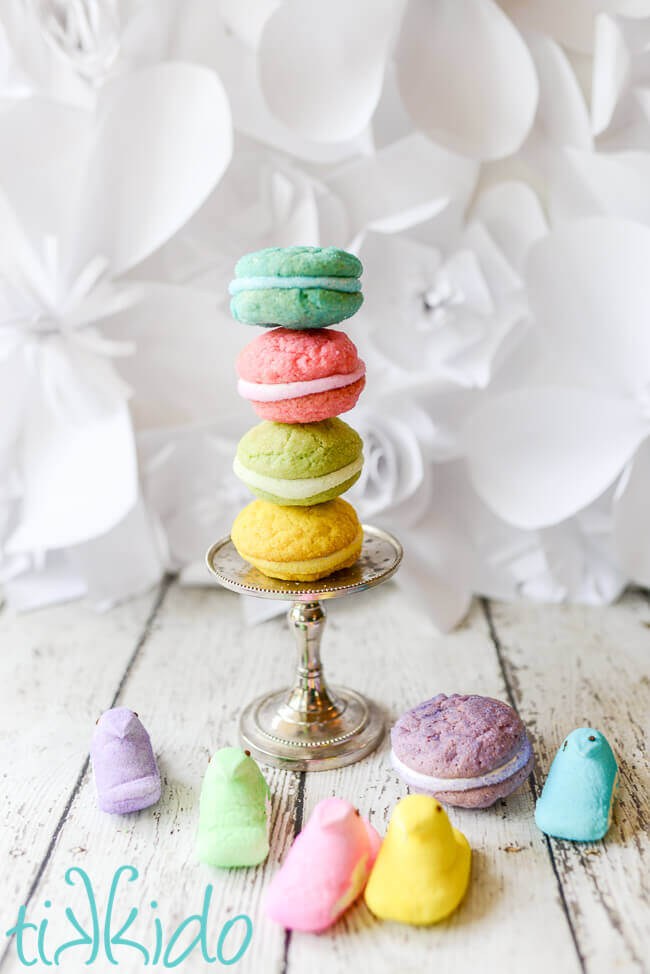 Easter whoopie pies stacked on a metal stand and surrounded by Peeps candies.