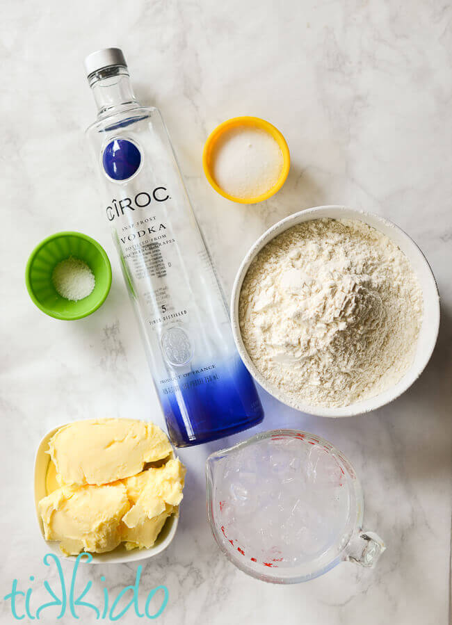 ingredients for Pie crust with vodka on a white marble surface.