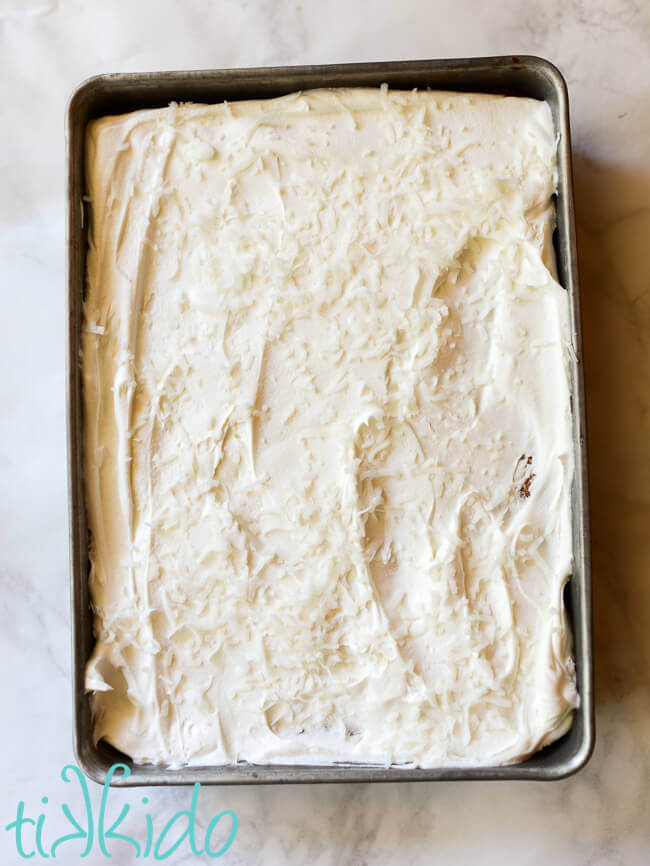 Pina Colada Cake topped with whipped cream and shredded coconut