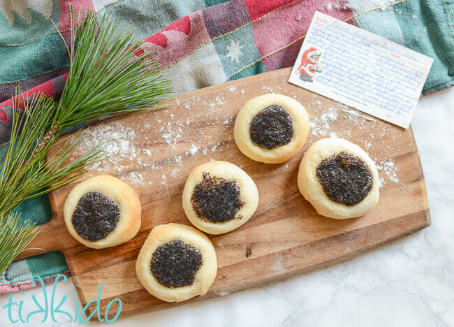Poppy Seed Kolache on a wooden cutting board dusted with flour, next to a hand written recipe card.