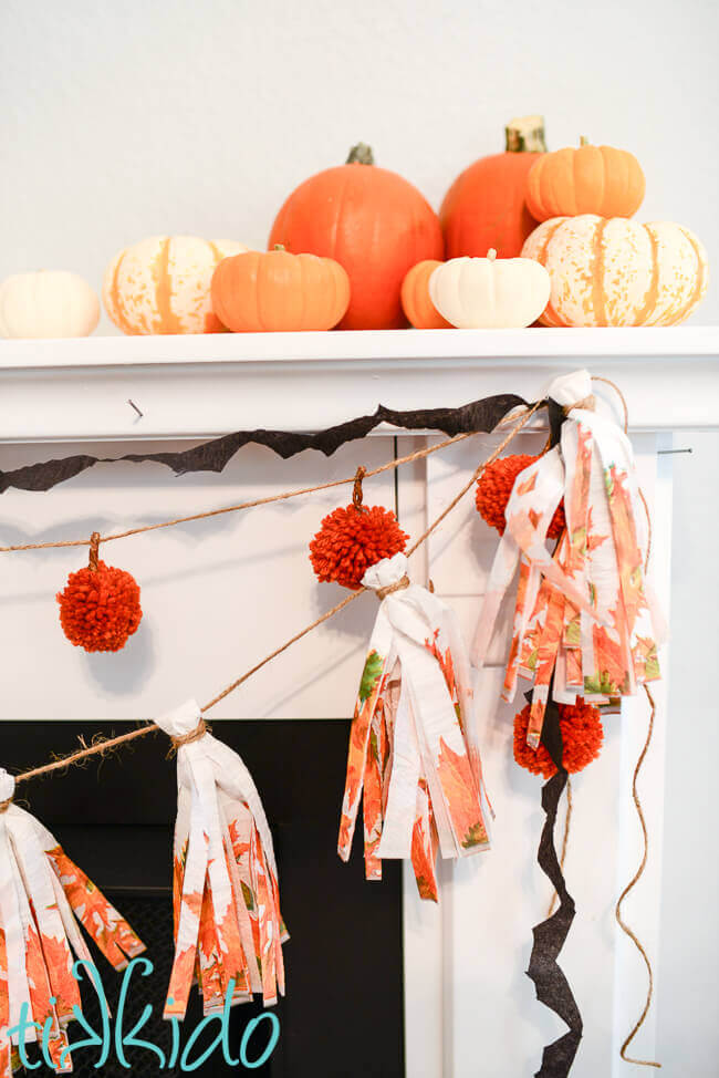 Crepe paper bat garland layered with pom pom pumpkin garland and napkin tassel garland.