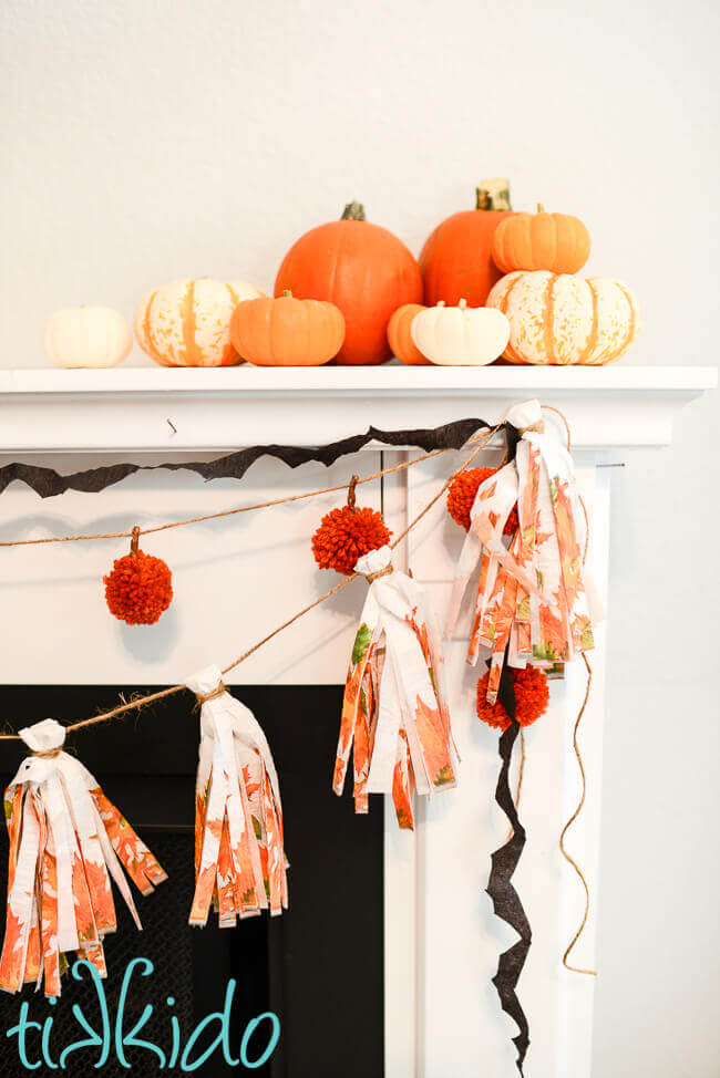 DIY tassel garland made with tissue paper tassels made from paper napkins decorating a fireplace.