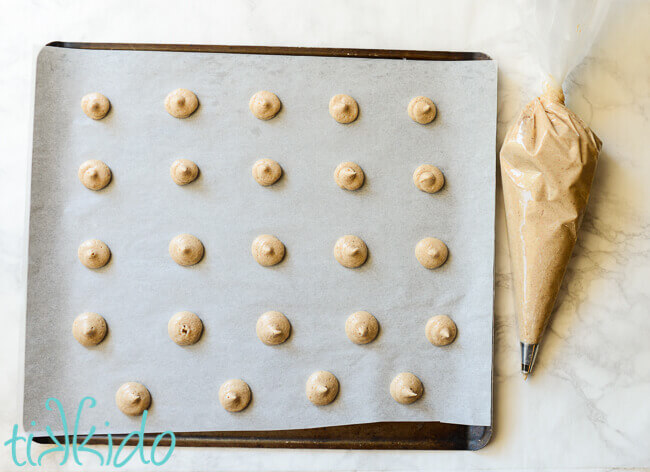 Pumpkin Spice Vanilla Wafer Cookies batter piped on a parchment lined cookie sheet.