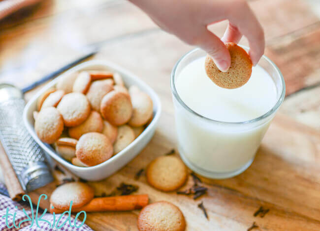Pumpkin Spice Vanilla Wafer Cookies being dunked in a glass of milk.