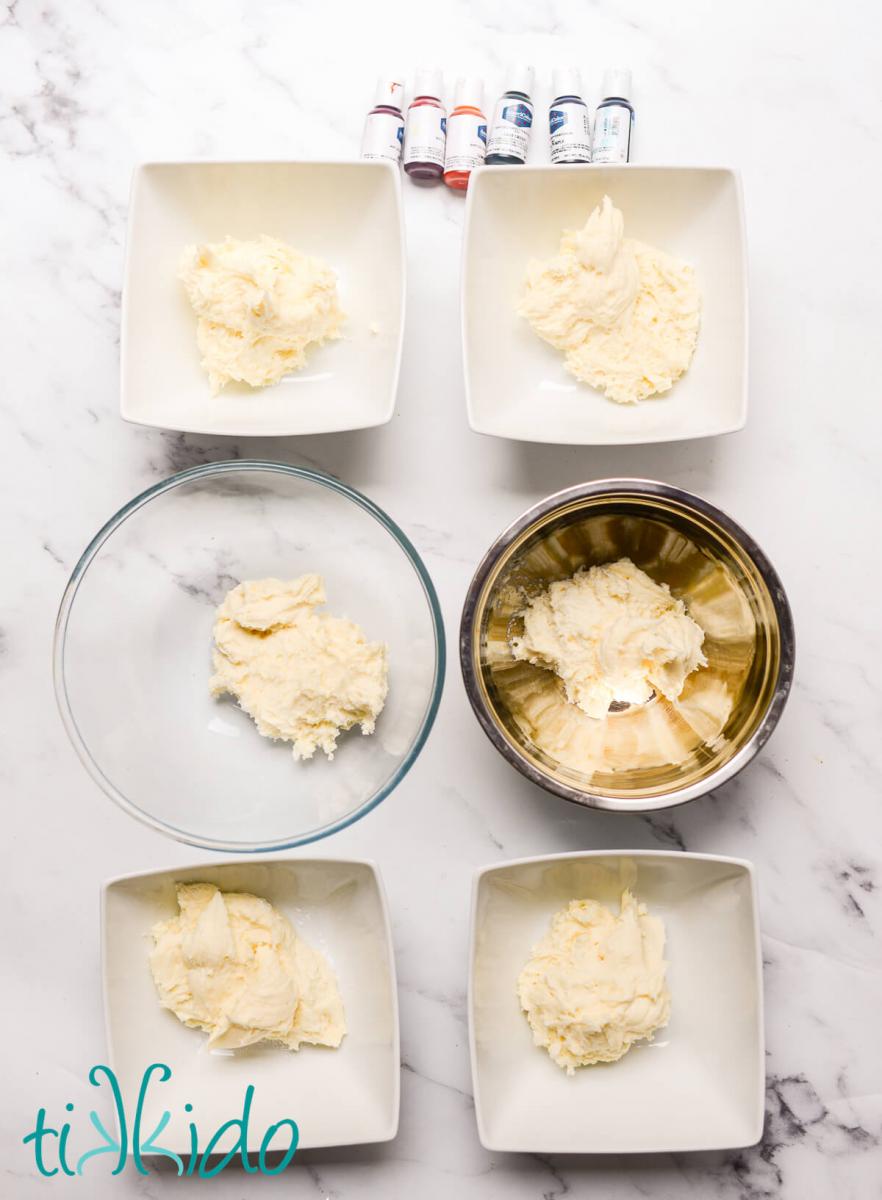 American buttercream divided into six bowls, ready to be colored using Americolor gel food coloring.