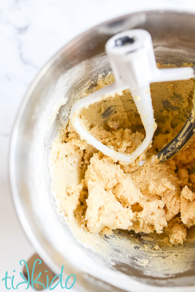 Shortbread cookie dough for the base layer of a Rhubarb Custard Bars Recipe in a kitchenaid mixing bowl.