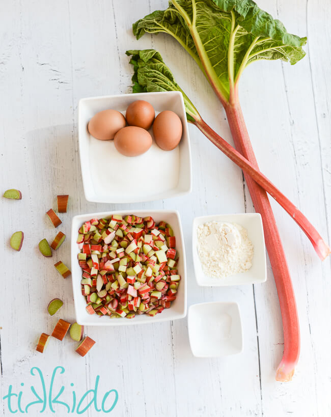 Ingredients for Rhubarb Custard filling for the Rhubarb Custard Bars Recipe on a white wooden surface.