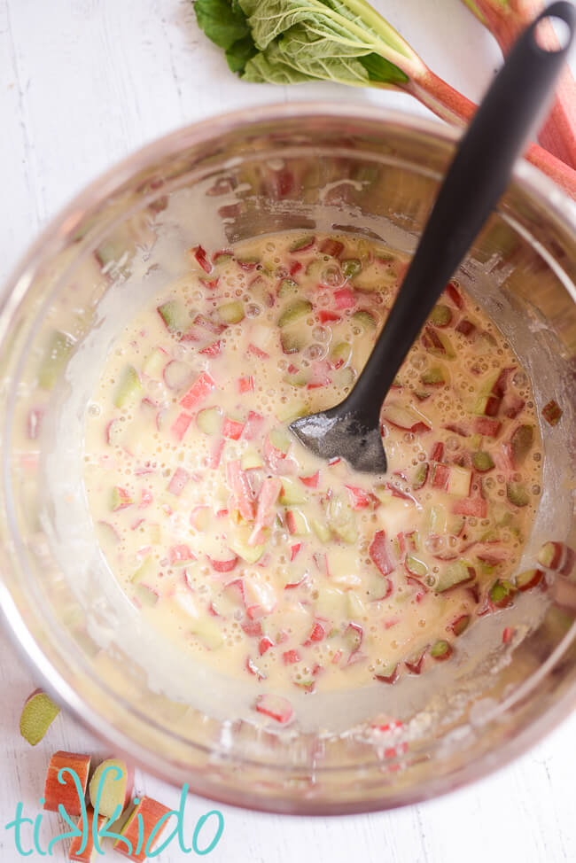 Rhubarb custard filling for rhubarb custard bars in a mixing bowl with a black spatula.