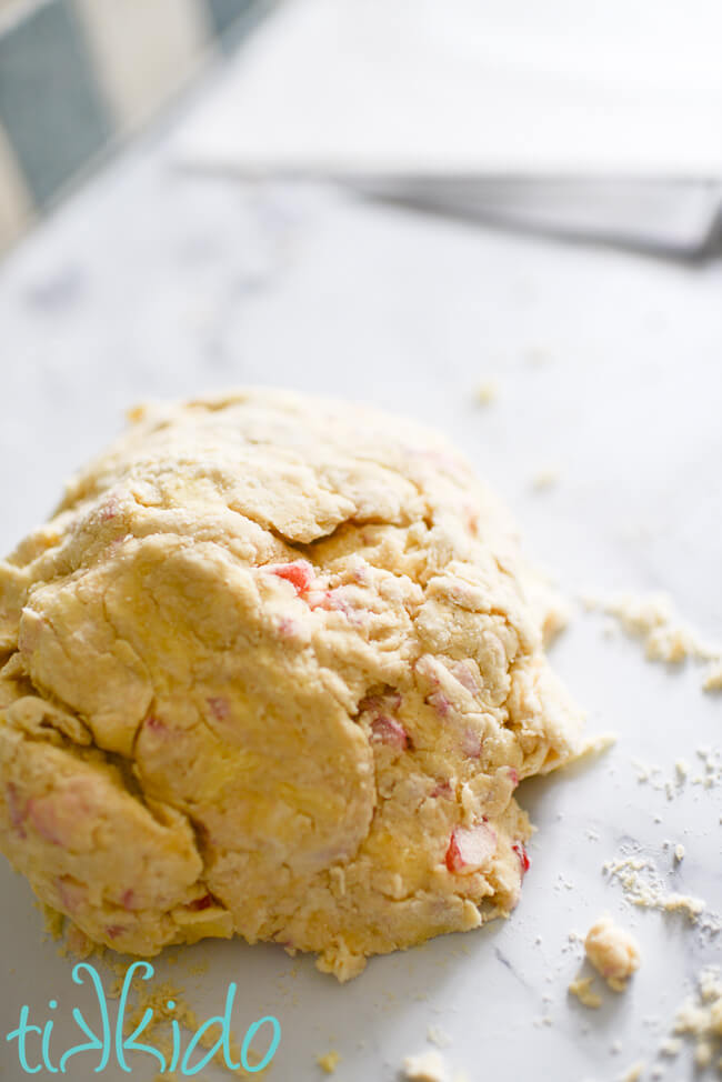 Rhubarb scones dough, freshly mixed, on a white marble surface.