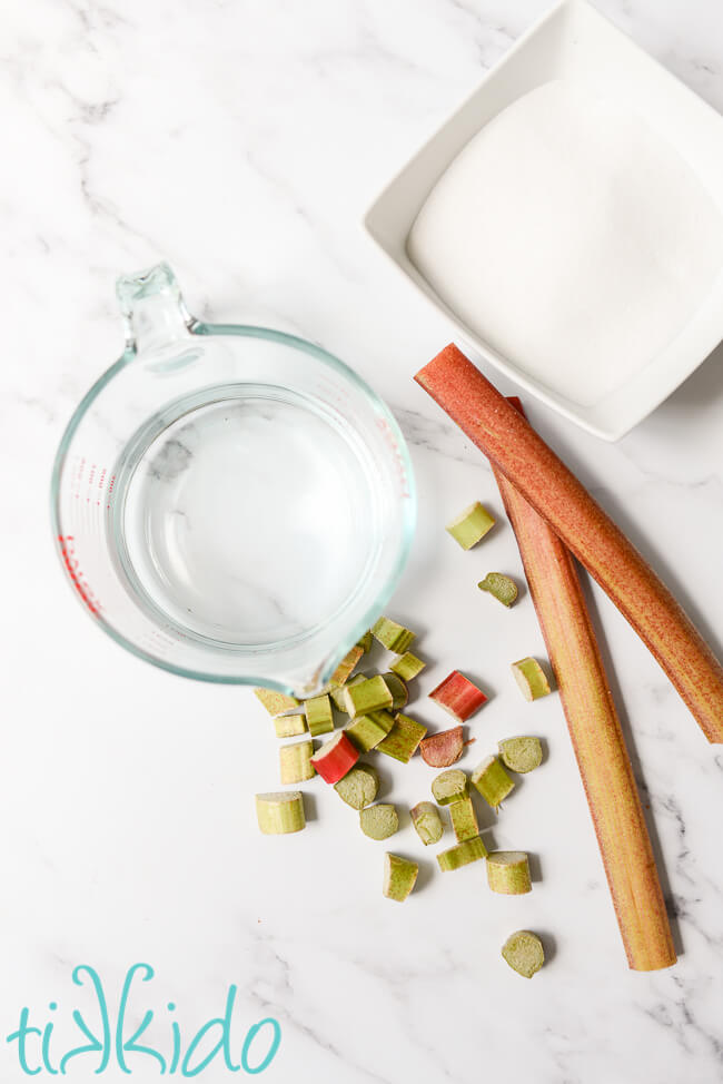 Ingredients for rhubarb syrup recipe on a white marble surface.