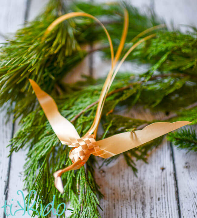 Golden Woven Ribbon Bird perched in a Christmas tree branch.