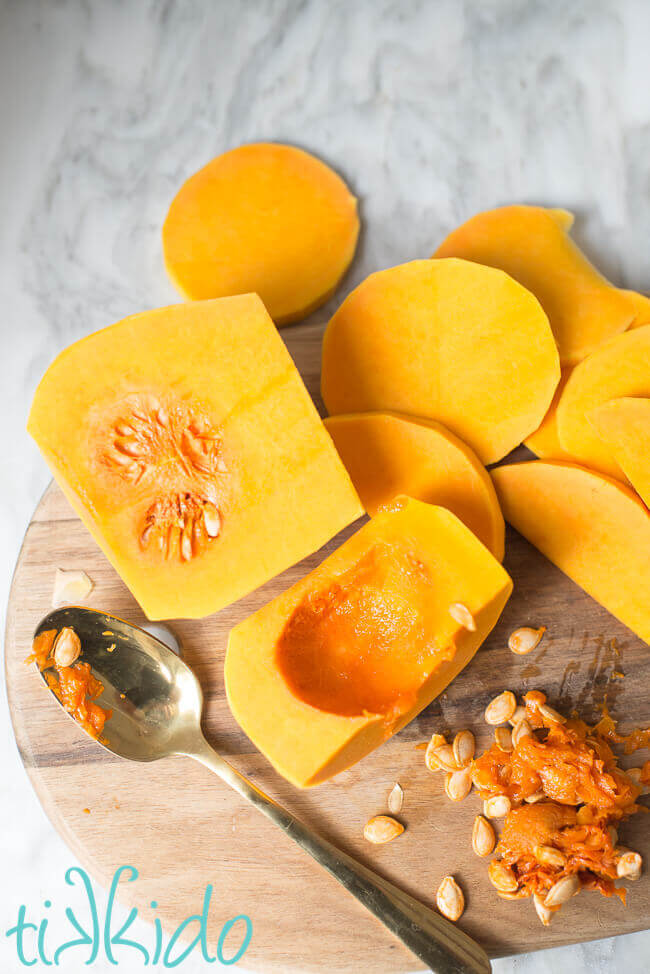 Butternut squash being cut and cleaned before roasting.