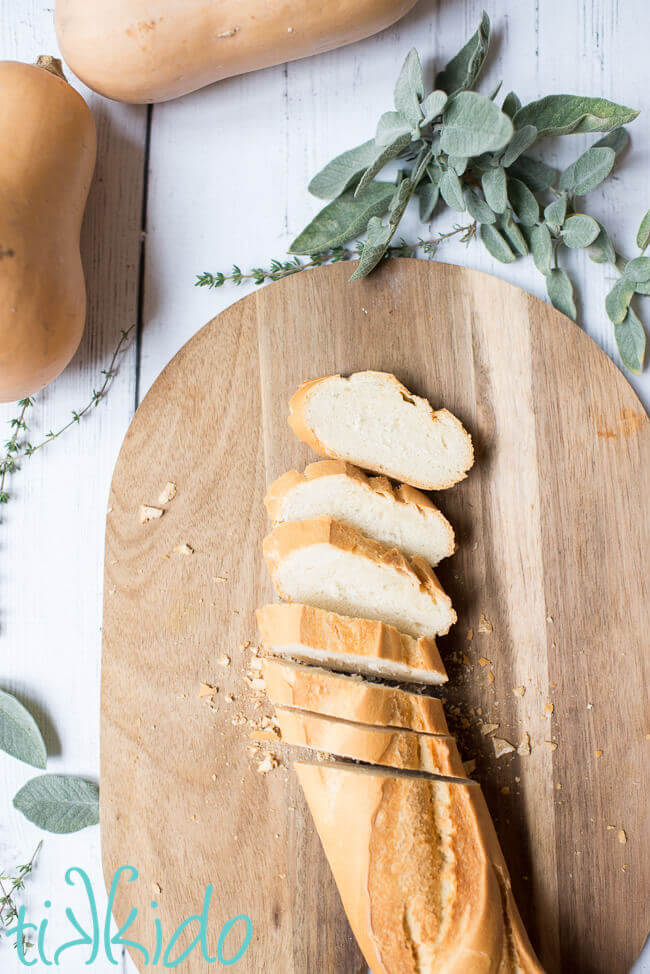 Sliced baguette on a cutting board, ready for making Butternut Squash Bruschetta