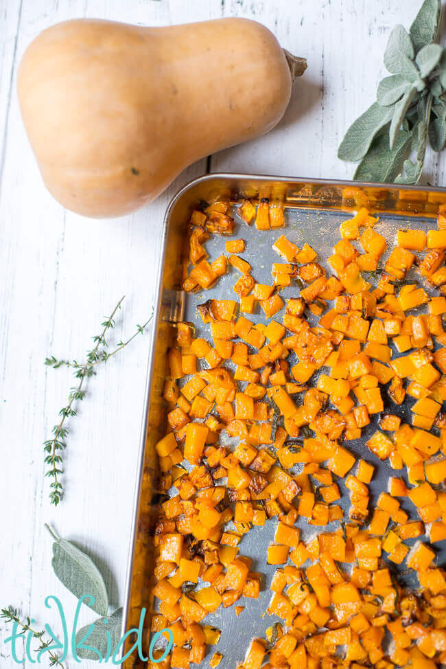 Sheet pan of roasted butternut squash with browned butter and herbs.