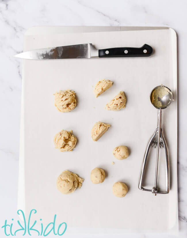 Russian Tea Cakes cookie dough being shaped into one inch balls before baking.