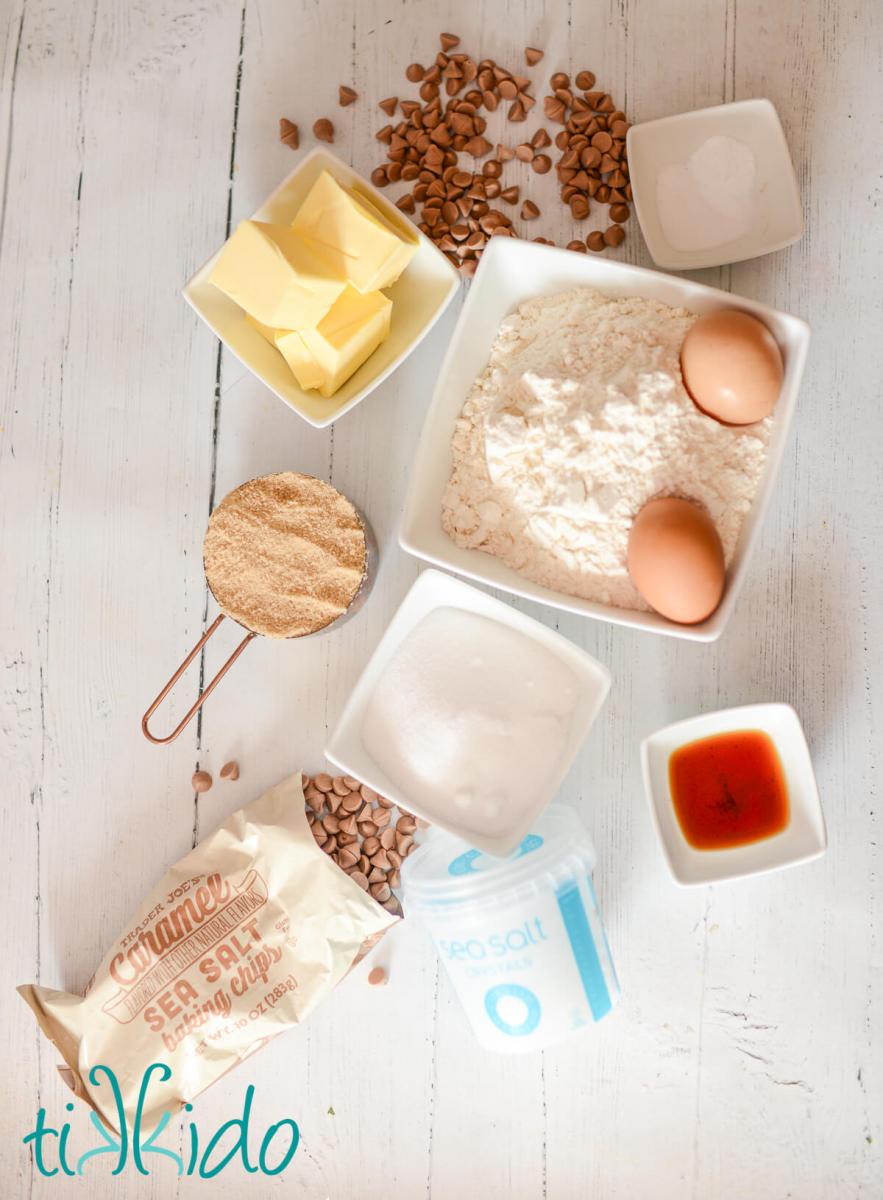 Salted caramel cookie ingredients on a white wooden surface.