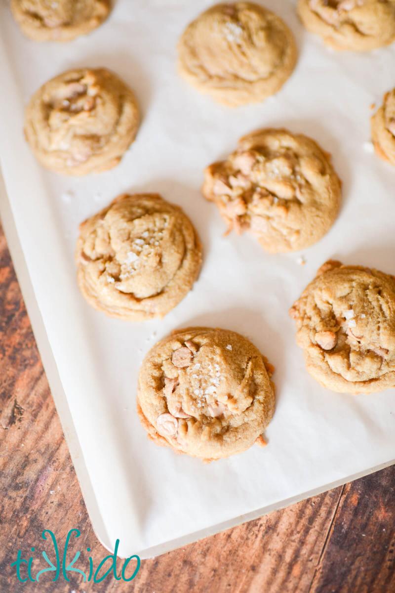 Salted caramel cookies, freshly baked on a parchment lined cookie sheet.