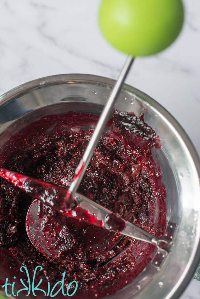 Food mill removing blackberry seeds from homemade blackberry jam.