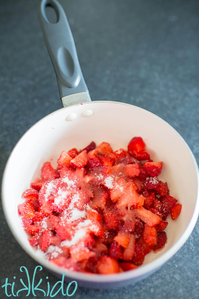 Chopped strawberries and sugar in a small saucepan for making quick strawberry jam with no pectin.