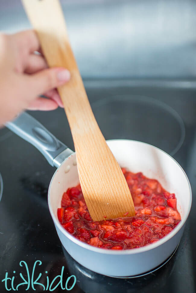 No pectin small batch strawberry jam cooking in a saucepan on the stove.