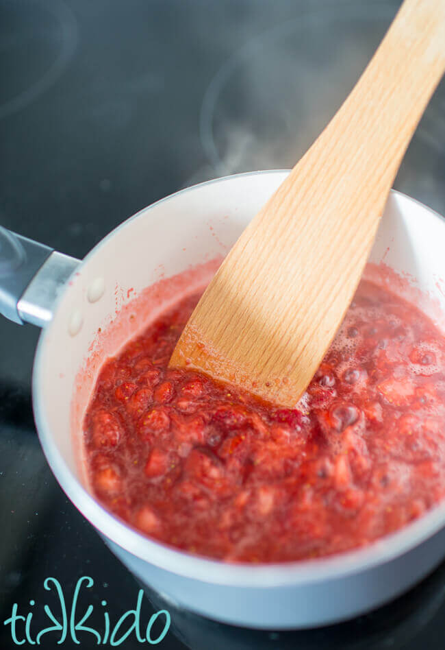 No pectin small batch strawberry jam cooking in a saucepan on the stove.