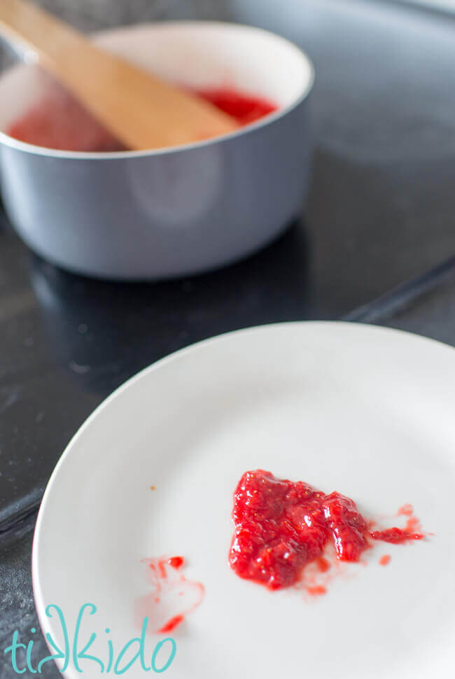 Testing no pectin strawberry jam on a cold white plate.