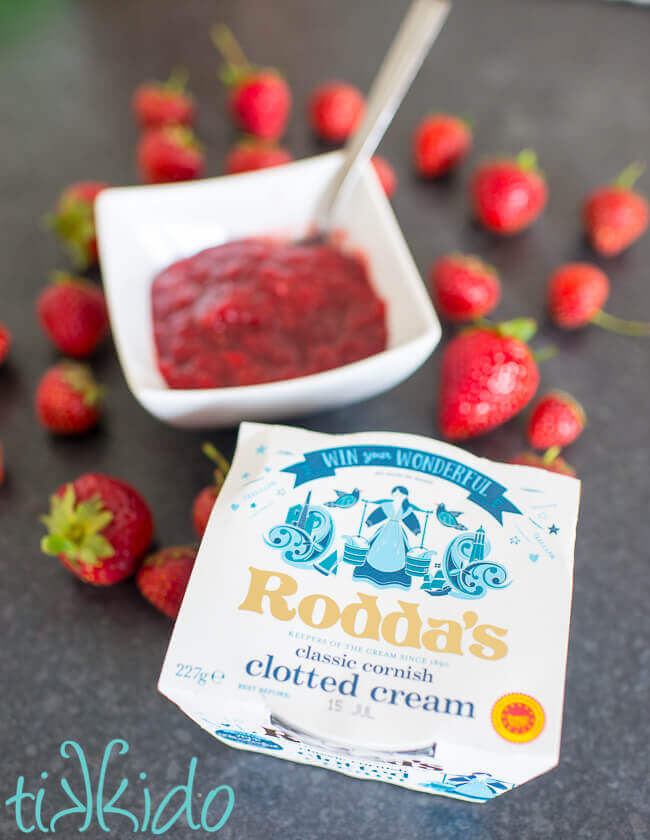 Bowl of quick strawberry jam next to a package of Rodda's clotted cream.