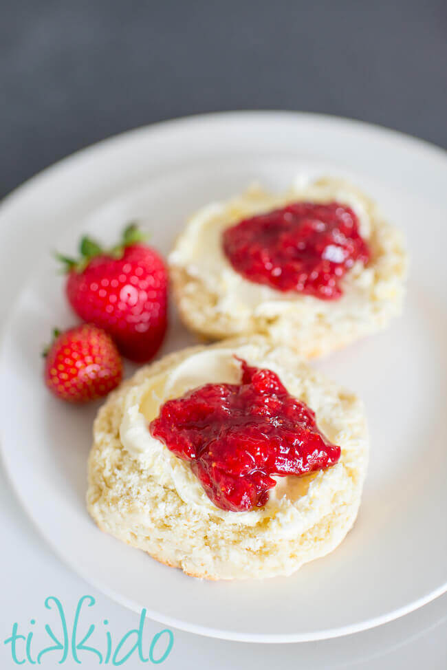 Small batch, no pectin quick strawberry jam on scones on a white plate.
