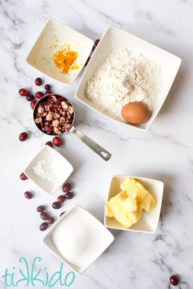 Ingredients for cranberry cookies on a white marble background.