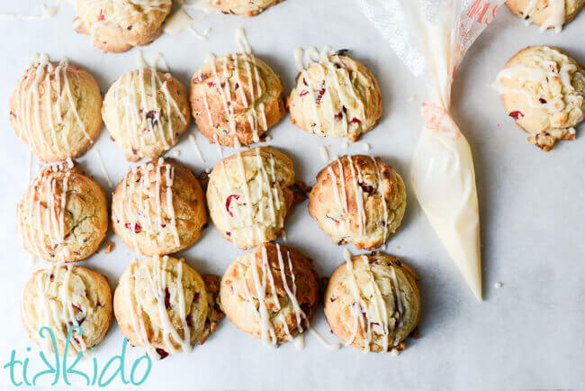 Orange glaze being drizzled on cranberry cookies.