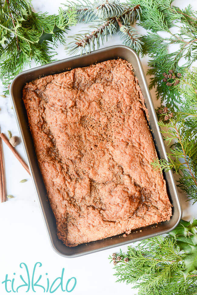 9x13 pan of sour cream coffee cake surrounded by Christmas greens.