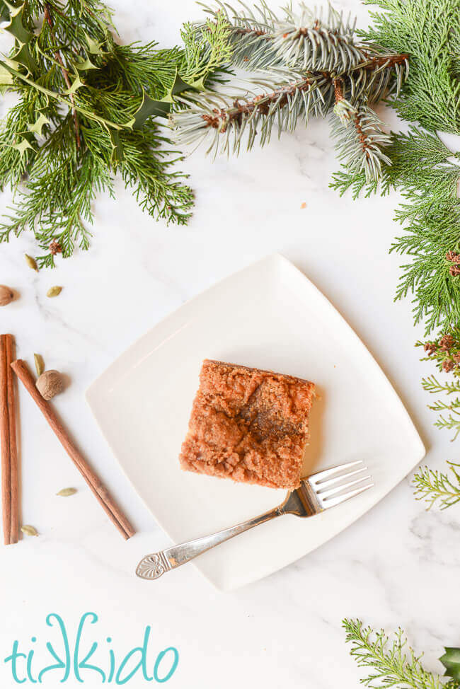 Piece of sour cream coffee cake on a white plate with a fork.