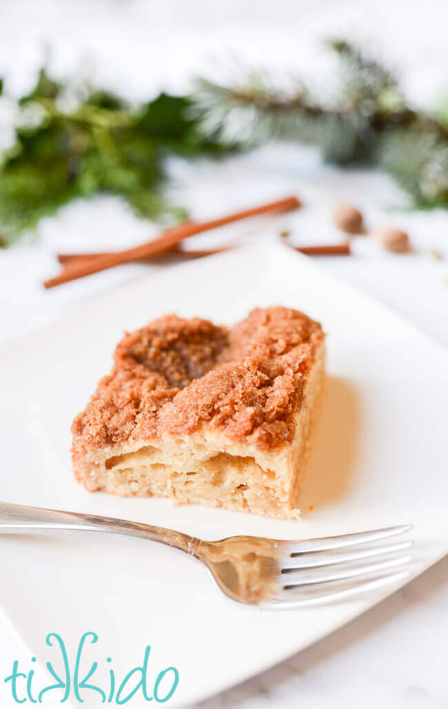 piece of sour cream coffee cake on a white plate.